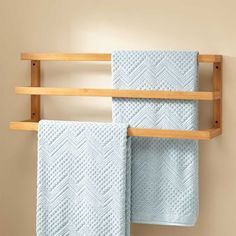 two towels are hanging on a wooden rack