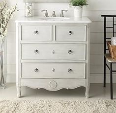 a bathroom with a white dresser and mirror