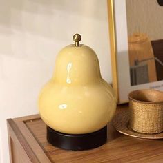 a yellow bell sitting on top of a wooden table