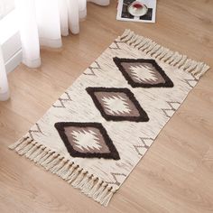 a white rug with brown and black designs on the floor next to a radiator