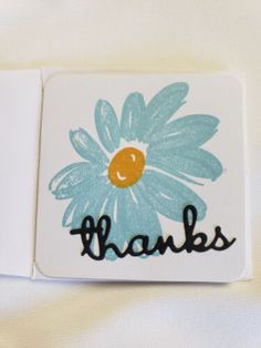 two square coasters with the words thanks and a painted blue flower on one side