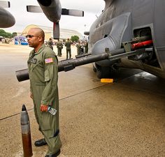 a man in uniform standing next to an airplane