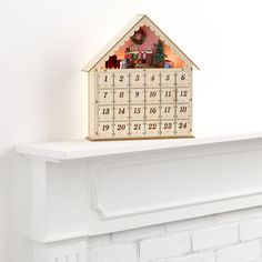 a house shaped clock sitting on top of a mantle