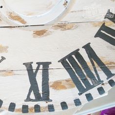 a close up of a painted sign with letters and numbers on the bottom part of it