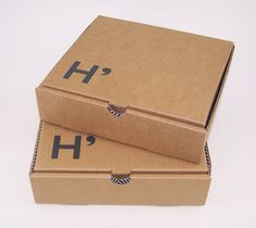 two cardboard boxes sitting side by side on a white surface, one with the letter h