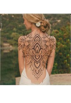 the back of a woman's body with intricate tattoos on her upper and lower back