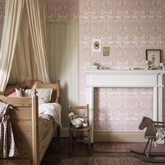 a child's bedroom with pink and white wallpaper