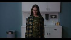 a woman standing in a kitchen with blue walls and cabinets behind her is smiling at the camera