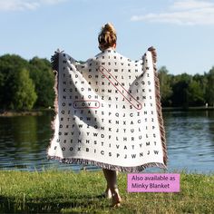 a woman is holding up a blanket with words on it