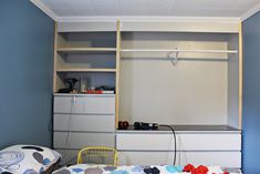 a bedroom with blue walls and white furniture