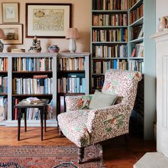 a living room filled with lots of books and furniture