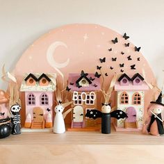 a group of halloween figurines sitting on top of a wooden table next to a wall