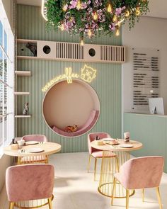 the interior of a restaurant with round tables and pink chairs in front of a green wall