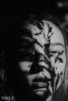 a woman's face is painted with black and white paint, while the image shows an animal pattern