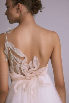 the back of a woman's wedding dress with ruffles and bows on it