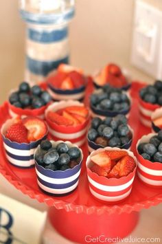 blueberries and strawberries in cups on a red tray