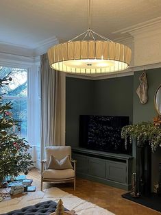 a living room filled with furniture and a christmas tree in front of a flat screen tv