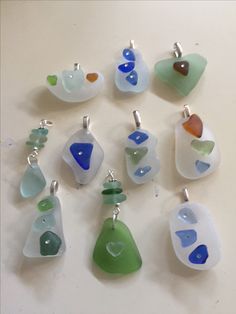 a collection of sea glass pendants sitting on top of a table