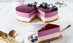 there is a cheesecake with blueberries on the top and one slice missing from it