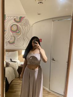 a woman is taking a selfie in the mirror while wearing a skirt and crop top