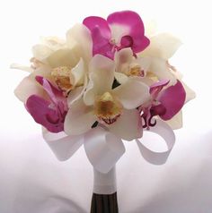 a bouquet of orchids and other flowers in a vase