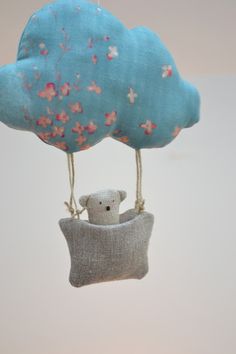 a stuffed animal hanging from a blue cloud