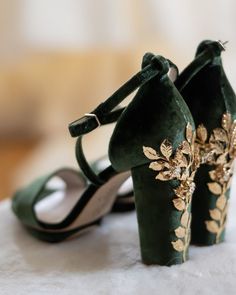 a pair of green high heeled shoes with gold appliques