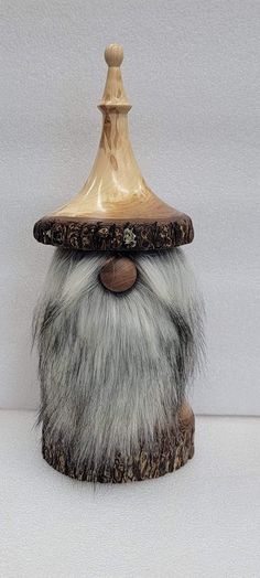 a small wooden gnome's head with white and gray hair