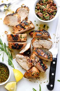 grilled pork chops on a cutting board with lemon wedges