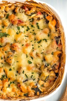 a casserole dish with cheese and vegetables in it on a wooden table top