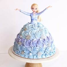 there is a cake that looks like a princess on top of it with blue frosting