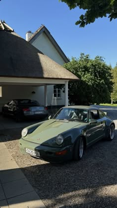 a green sports car parked in front of a house