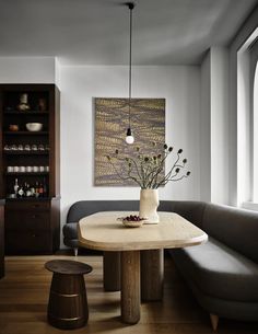 a living room with a couch, table and shelves filled with vases on top of it