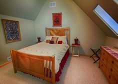 a bed room with a neatly made bed and dresser