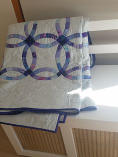 two quilts sitting on top of each other in front of a window sill