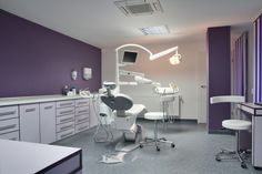 a dentist's office with purple walls and white chairs