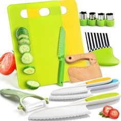 a green cutting board with cucumbers, tomatoes and knifes