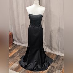 a mannequin wearing a black evening gown