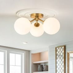 a living room filled with furniture and two lamps on top of the ceiling over a fire place