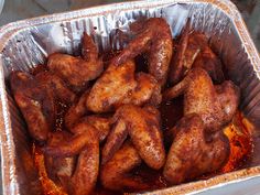 chicken wings in tin foil sitting on top of a counter