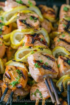 chicken kabobs on skewers with lemons and parsley are ready to be grilled