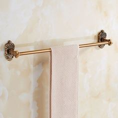 a gold towel rack with two towels hanging on it