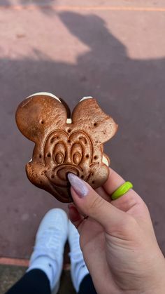 a person holding up a fake mickey mouse cookie