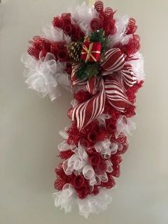 a red and white christmas wreath hanging on the wall