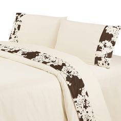 an image of a bed with black and white flowers on the comforter sheet set