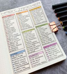 an open planner with markers and pens on it