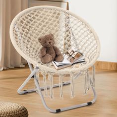 a teddy bear sitting in a chair with books on the table next to it,