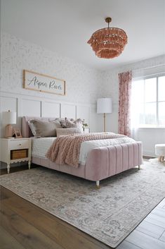 a bedroom with a pink bed and white walls, wooden floors and a chandelier hanging from the ceiling