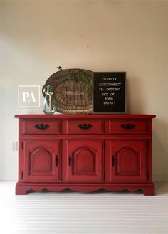 a red dresser sitting on top of a white floor