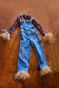 an old pair of denim overalls with frayed edges and fringed ends laying on a wooden surface